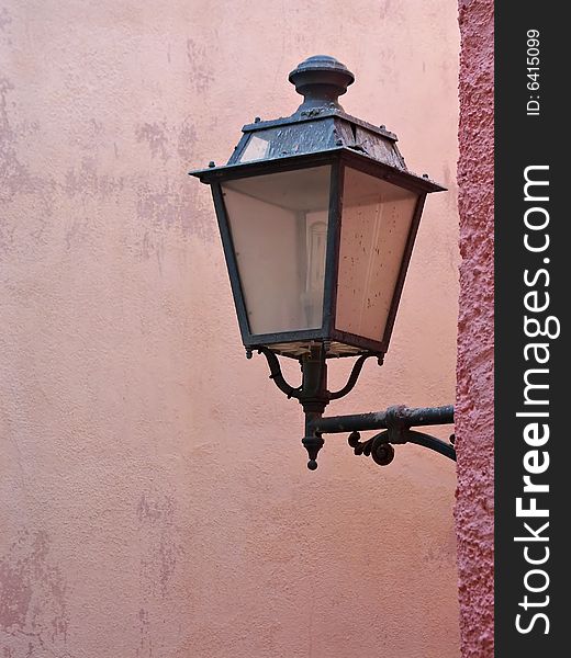 Street lamp hanging from a pink wall in Lisbon, Portugal. Street lamp hanging from a pink wall in Lisbon, Portugal