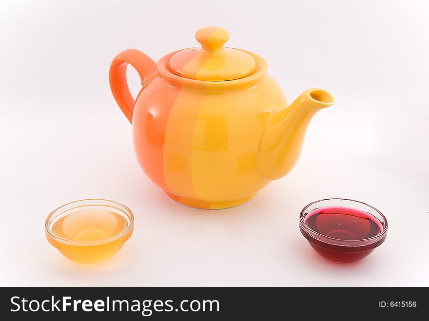 Teapot with red and yellow sirup on white. Teapot with red and yellow sirup on white