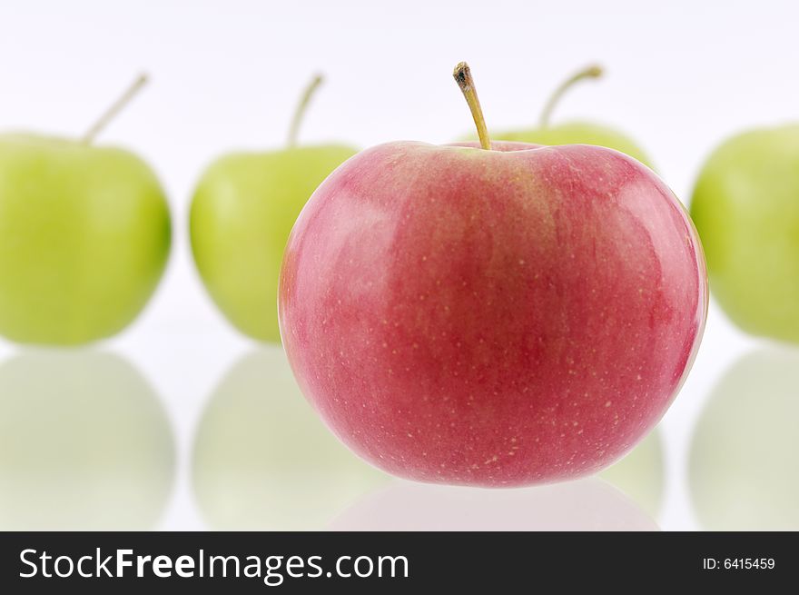 One red apple in front with green apples in the foreground