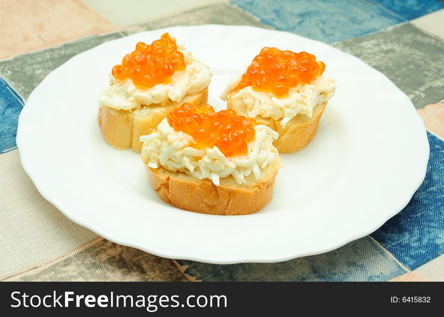 Three caviar sandwiches on white plate