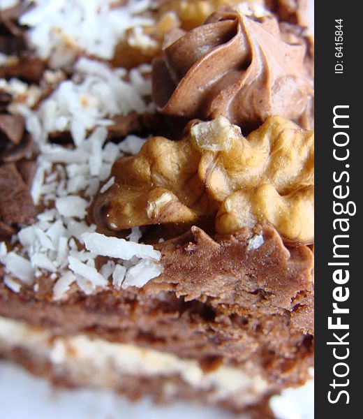 Chocolate cake covered with dried coconut, walnuts and coating glaze