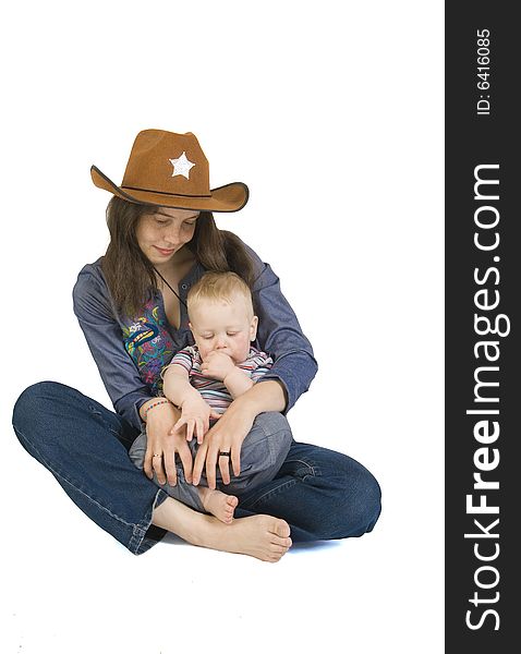 The beautiful young woman sitting on a floor, holds on hands of the small child. Isolated on a white background. The beautiful young woman sitting on a floor, holds on hands of the small child. Isolated on a white background.