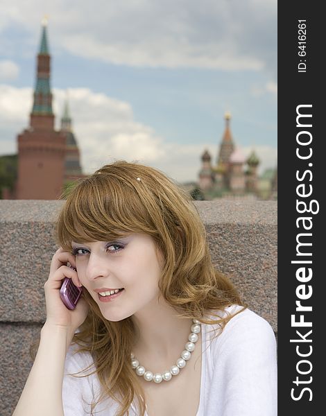 A photo of beautiful woman talking on the phone in Moscow near the Kremlin. A photo of beautiful woman talking on the phone in Moscow near the Kremlin