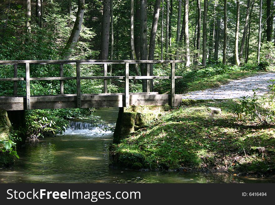 Crear water runs beneath the wooden bridge in a park