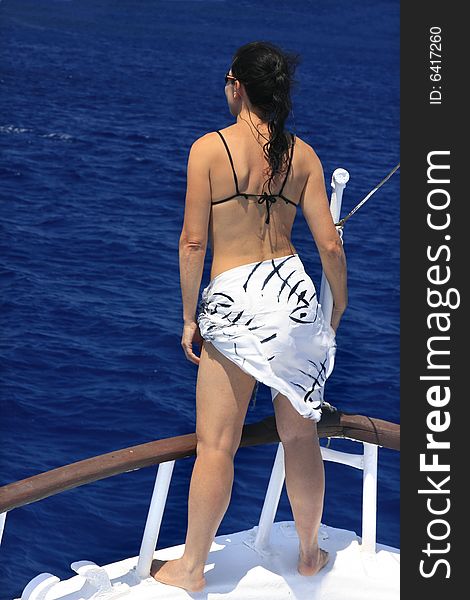Woman enjoying a sunny summer day on a boat; position inspires freedom. Woman enjoying a sunny summer day on a boat; position inspires freedom.