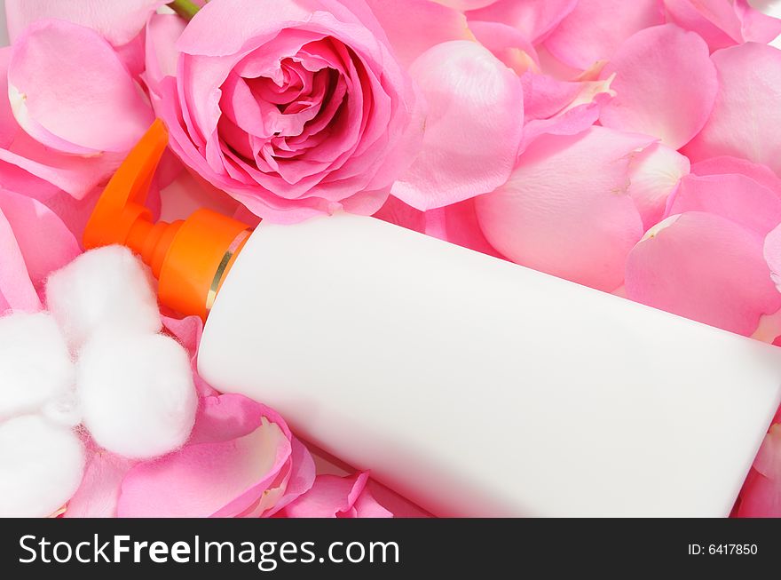 Blank skin care lotion with rose petals and cotton swabs. Blank skin care lotion with rose petals and cotton swabs