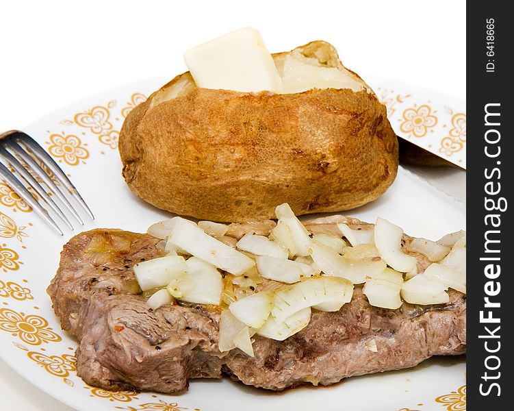 A grilled steak smothered with onions with a hot buttered baked potato. A grilled steak smothered with onions with a hot buttered baked potato