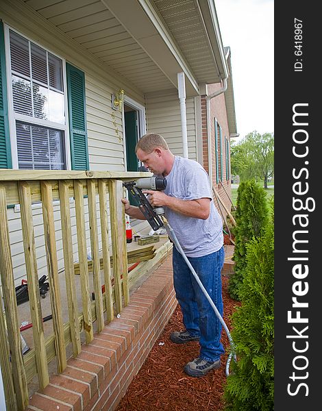 Carpenter is adding rails to porch on front of house, will add value for resale. Carpenter is adding rails to porch on front of house, will add value for resale