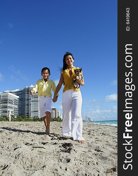 Beautiful young mother walking with her son on the beach. Beautiful young mother walking with her son on the beach.