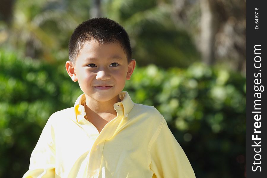 Young boy wearing a yellow business shirt and smiling. Young boy wearing a yellow business shirt and smiling.