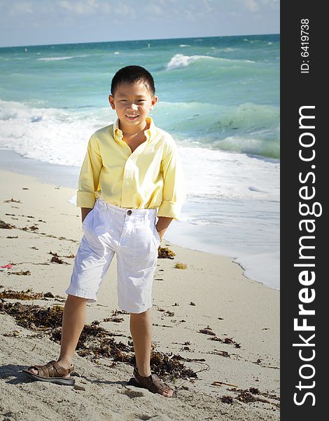 Young boy smiling and posing by the sea shore. Young boy smiling and posing by the sea shore