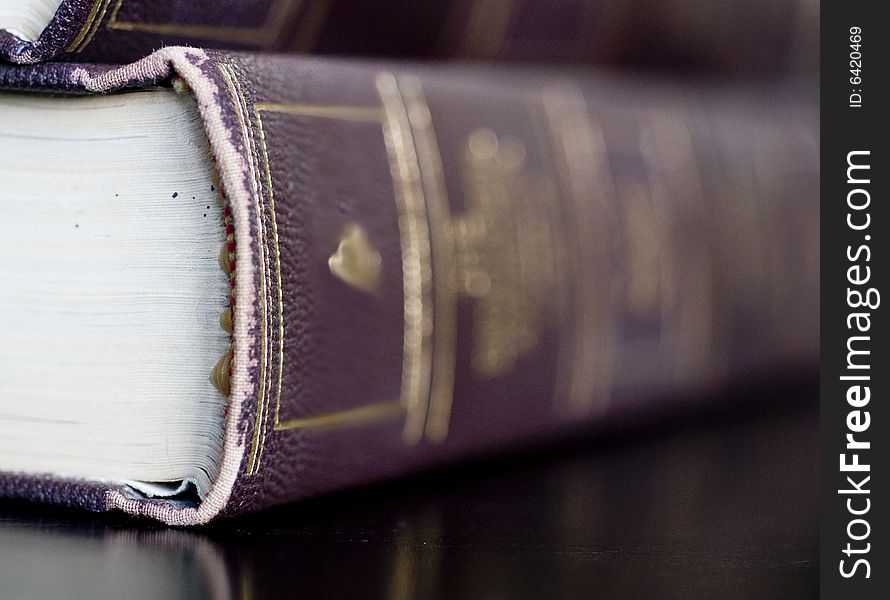 Beautiful leather bound books on a dark wood table