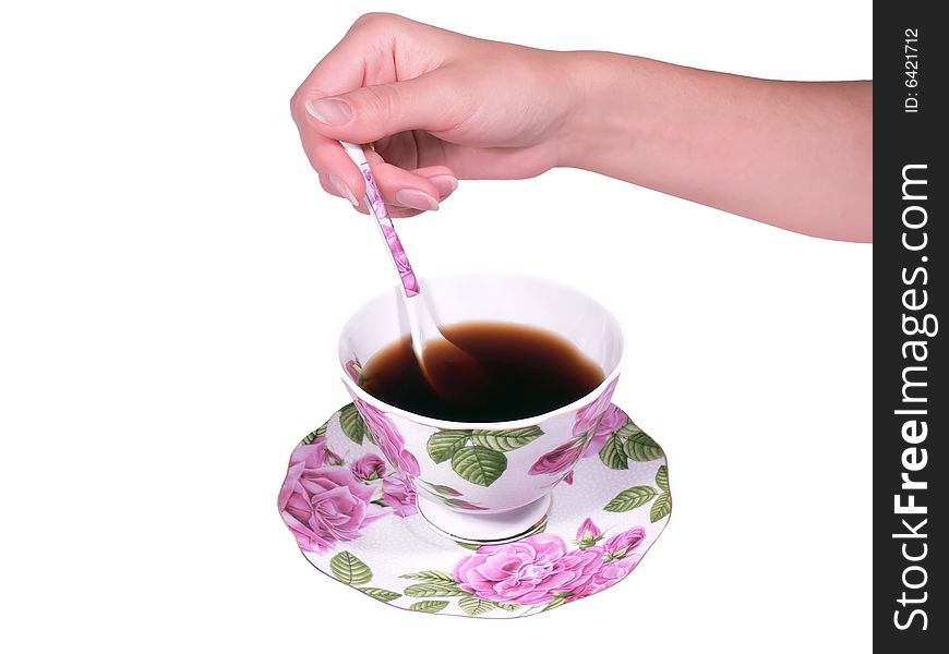The female hand a spoon stirs tea or coffee