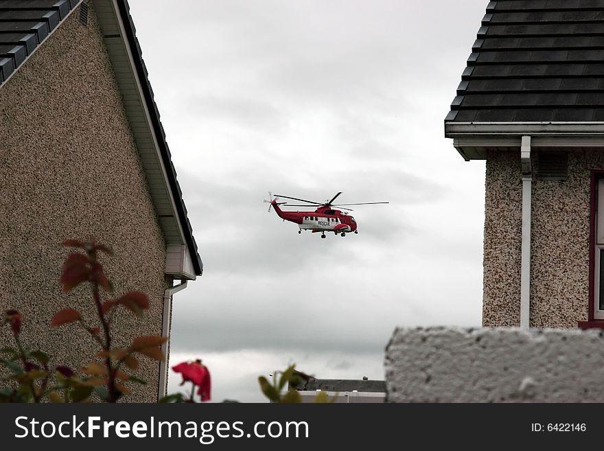 A helicopter on a life air sea rescue mission over an urban area in ireland. A helicopter on a life air sea rescue mission over an urban area in ireland