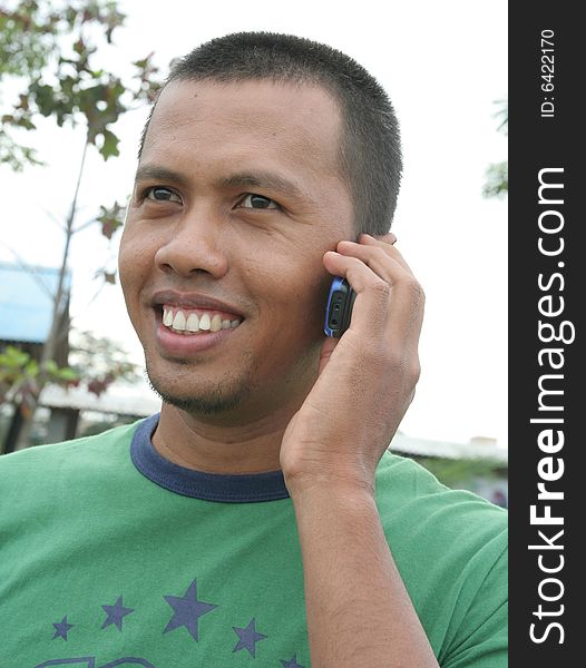 Asian calling on cellular outdoor smiling. Asian calling on cellular outdoor smiling