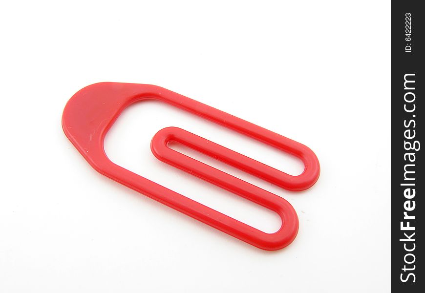 Red plastic paper clip isolated over white background.