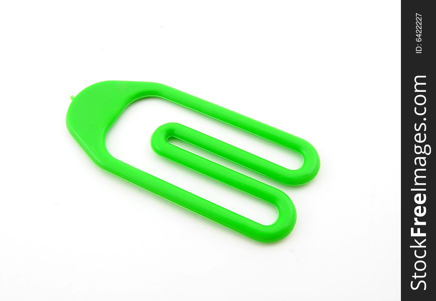 Green plastic paper clip isolated over white background.