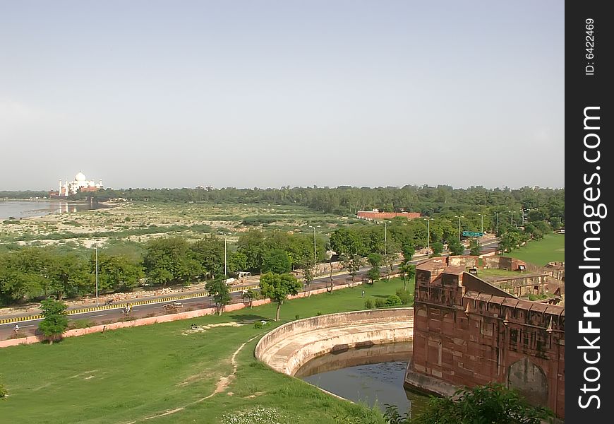 A remote view of Taj Mahal with surrounding river, the red fort and greenery. This photo has copy space. A remote view of Taj Mahal with surrounding river, the red fort and greenery. This photo has copy space