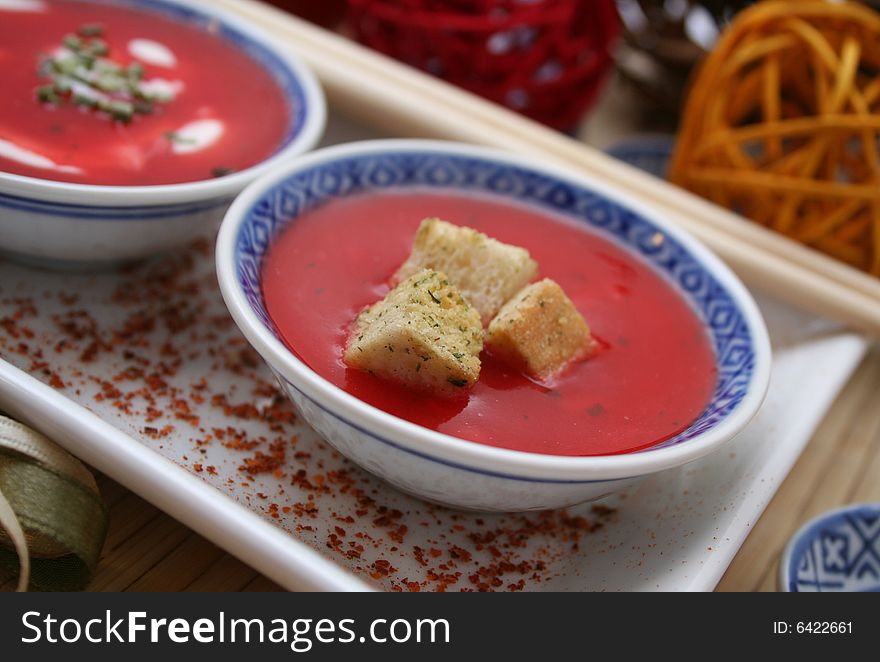 A soup of tomatoes with some croutons