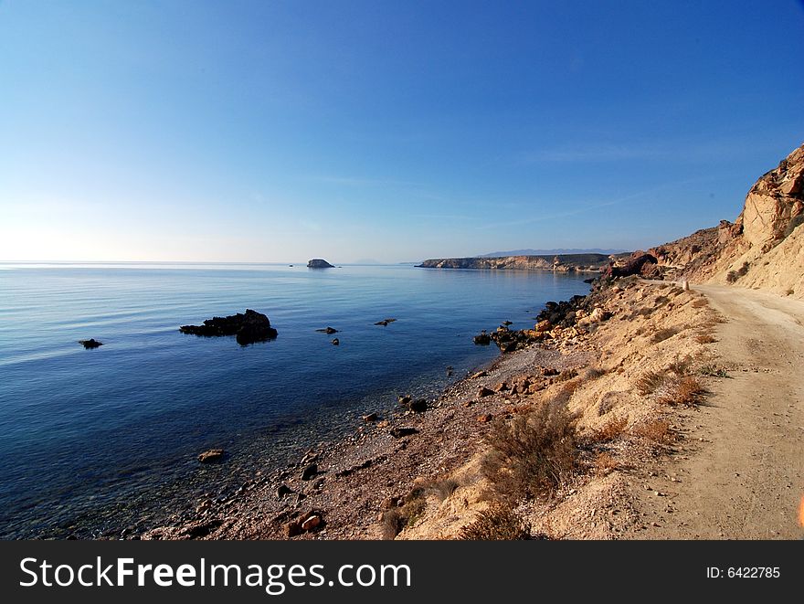 A dirt track running alongside an undeveloped part of the Mediterranean Sea in Spain. A dirt track running alongside an undeveloped part of the Mediterranean Sea in Spain