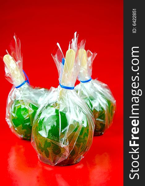 Toffee apples isolated against a green background