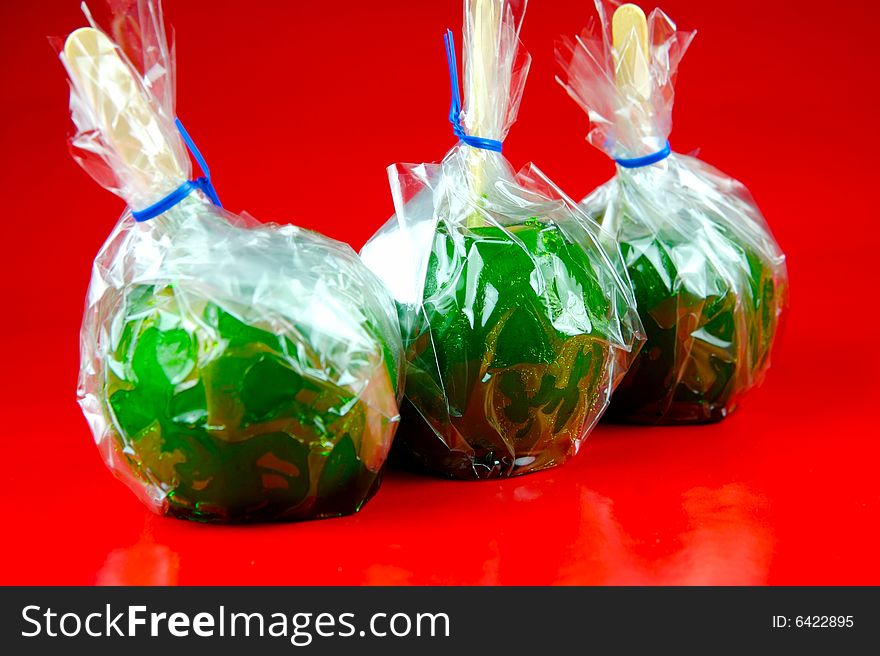 Toffee apples isolated against a green background