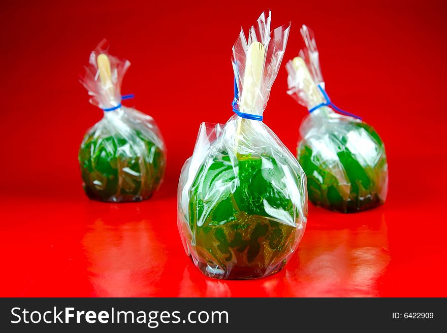 Toffee apples isolated against a green background