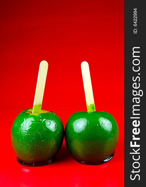 Toffee apples isolated against a green background