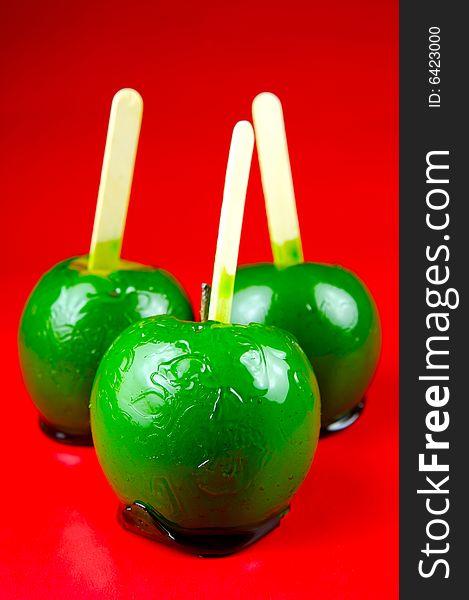 Toffee apples isolated against a green background