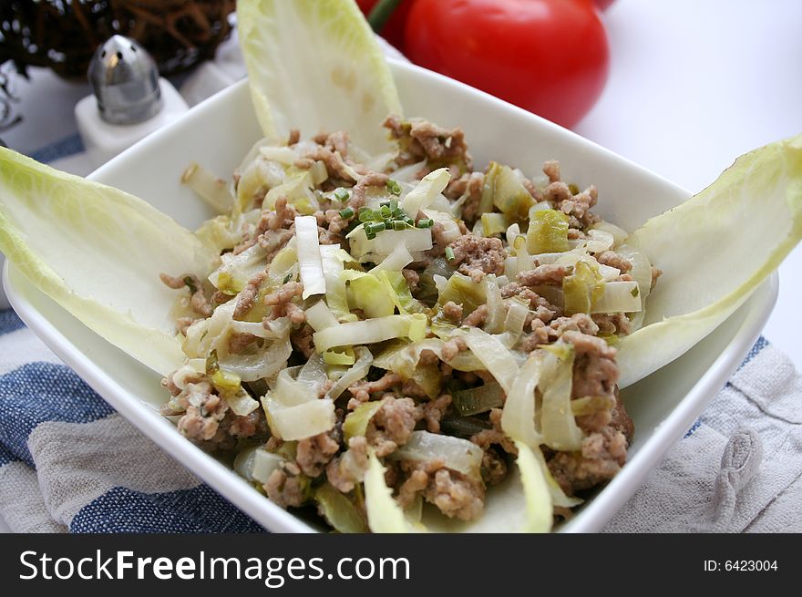 A meal of fresh chicory and some meat. A meal of fresh chicory and some meat