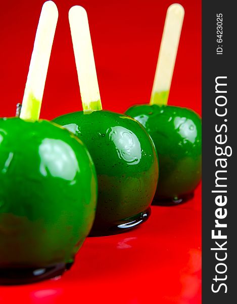 Toffee apples isolated against a green background