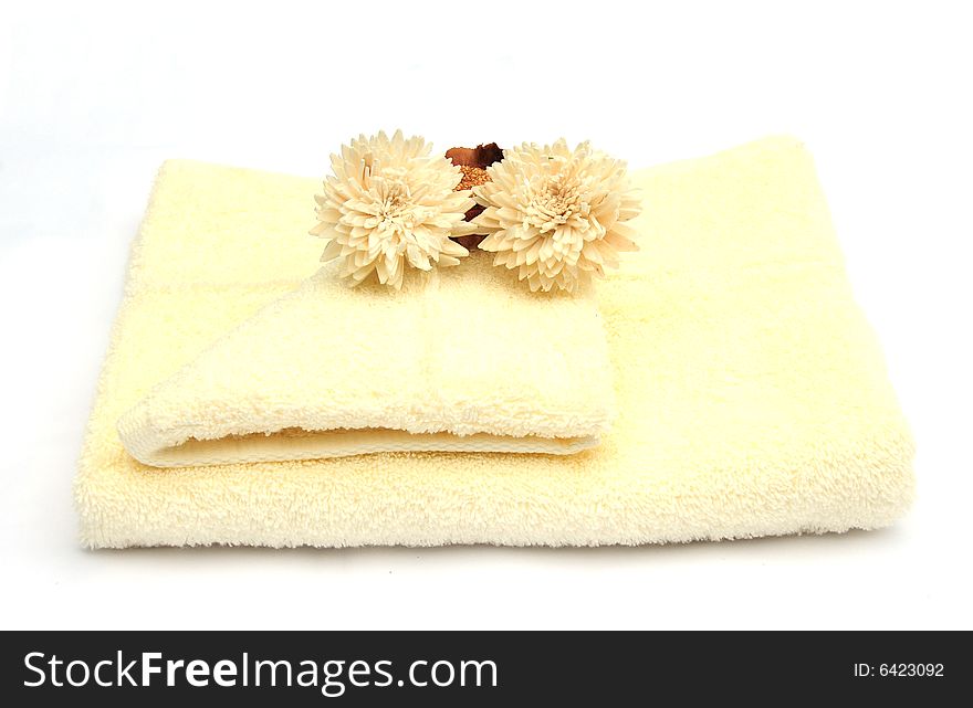 Shot of three different coloured towels and flowers