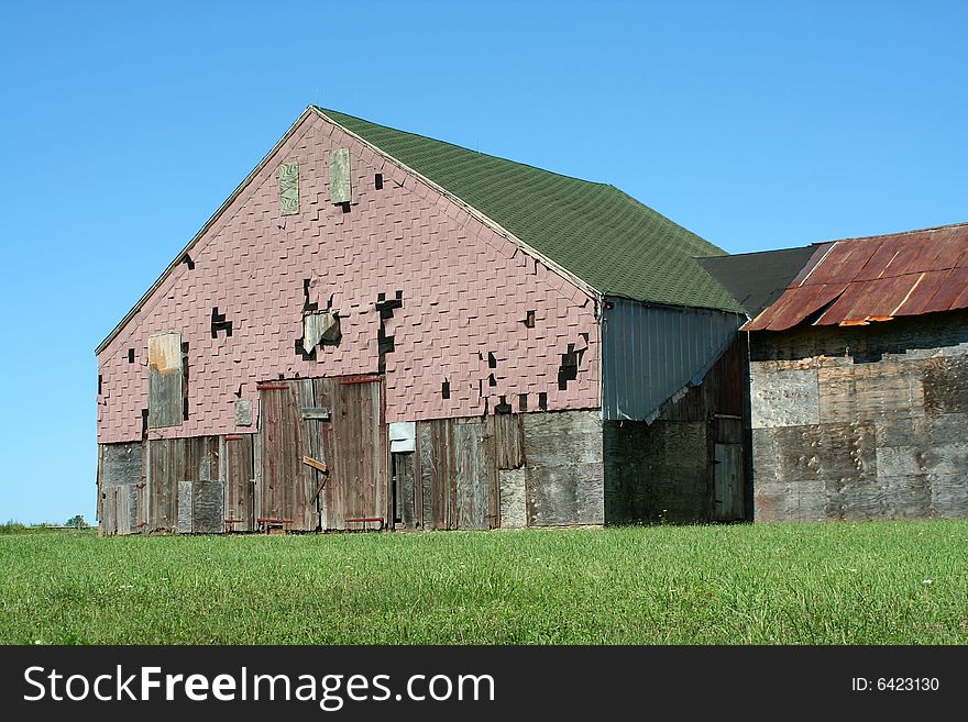 A Old barn with grass and blue sky