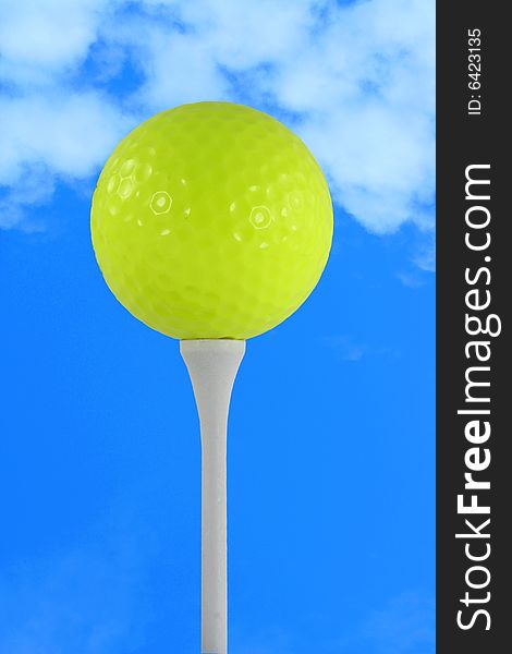 A Yellow golf ball against blue sky