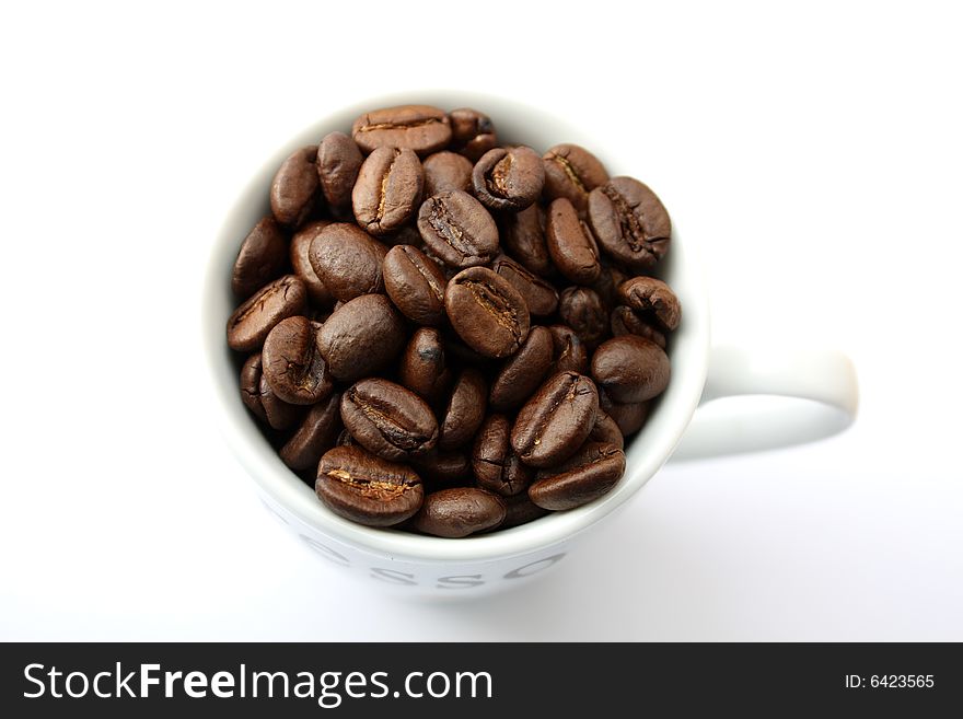 An espresso cup full of coffee beans