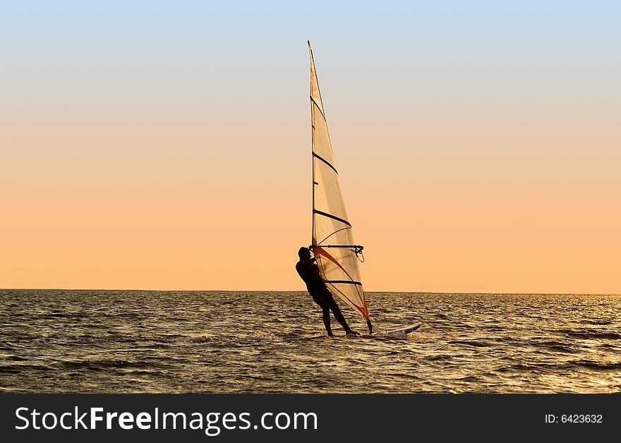 Silhouette of a windsurfer on waves