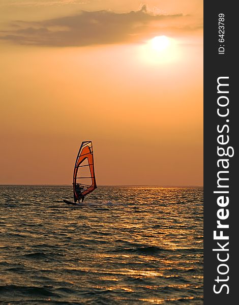 Silhouette of a windsurfer on a gulf on a sunset