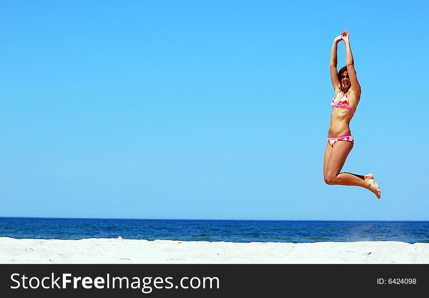 Young attractive woman jump on the beach. Young attractive woman jump on the beach