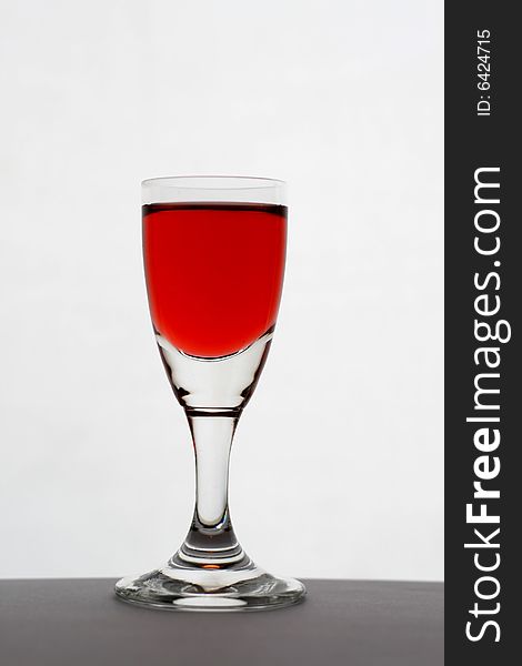 A glass of wine on the table, over white background