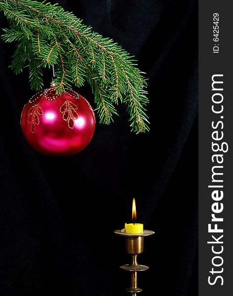 Green  fir tree  twig and red ball and candle. Green  fir tree  twig and red ball and candle