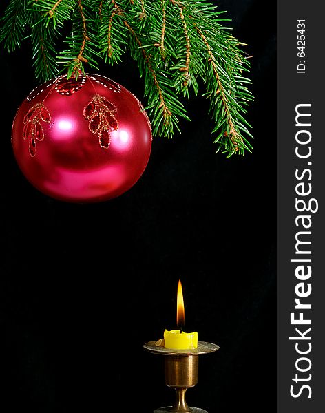 Green  fir tree  twig and red ball and candle. Green  fir tree  twig and red ball and candle