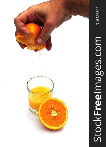 Shot of someone squeezing an orange into a glass. Shot of someone squeezing an orange into a glass