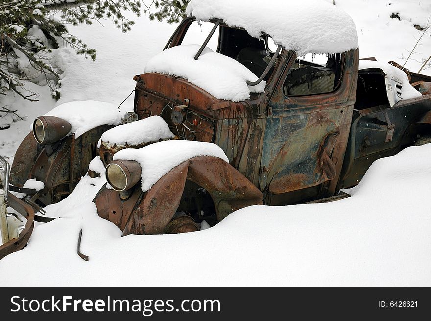 A vintage car left to rust in a secluded spot in the Rocky Mountain forest. A vintage car left to rust in a secluded spot in the Rocky Mountain forest.