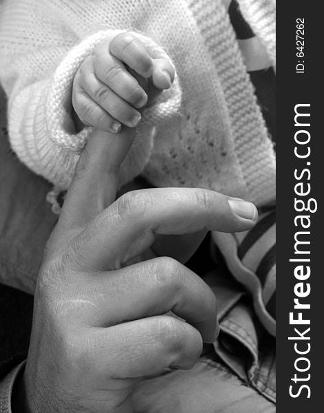 Baby hand grasping onto fathers index finger. Baby hand grasping onto fathers index finger