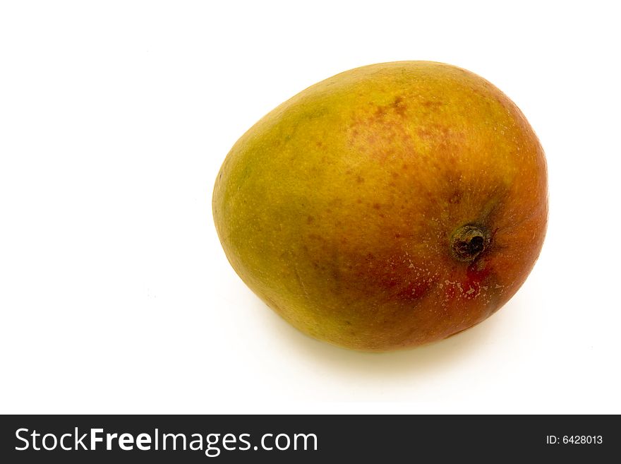 A ripe mango fruit isolated on white with a soft shadow. A ripe mango fruit isolated on white with a soft shadow