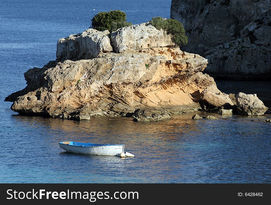 Rock in a sea with a boat in Majorca in Spain. Rock in a sea with a boat in Majorca in Spain