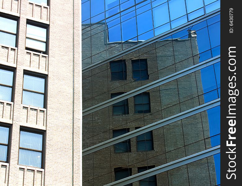 View of two buildings, the older one reflected in the modern builing. View of two buildings, the older one reflected in the modern builing.