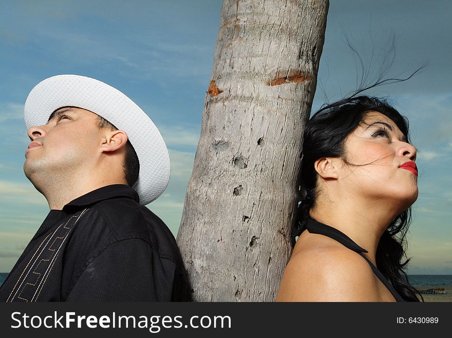 Couple with a palm tree bark in between them. Couple with a palm tree bark in between them.