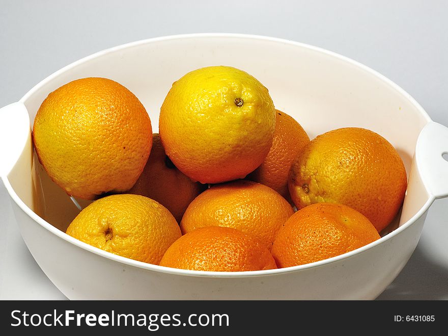 Fresh orange in a bowl on white background