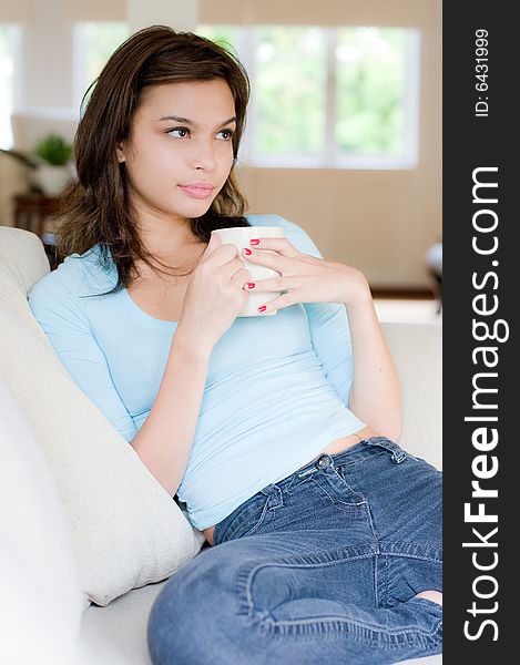 An attractive young woman drinking coffee at home. An attractive young woman drinking coffee at home